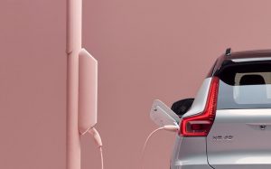 Volvo empresa sustentable, vista trasera a faro de SUV XC40 color plata conectada a terminal eléctrica